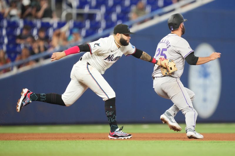 May 2, 2024; Miami, Florida, USA;  Colorado Rockies catcher Jacob Stallings (25) gets caught in a run-down by Miami Marlins third baseman Emmanuel Rivera (15) in the fifth inning at loanDepot Park. Mandatory Credit: Jim Rassol-USA TODAY Sports