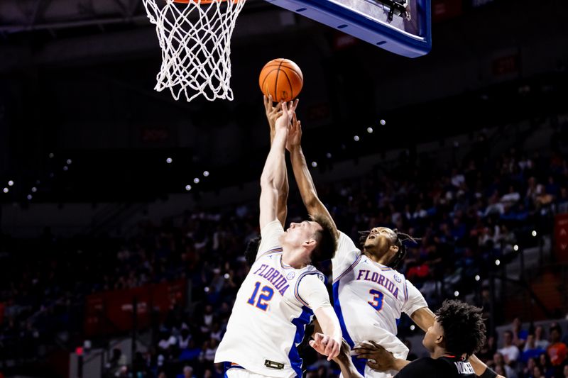 Jan 7, 2023; Gainesville, Florida, USA; Florida Gators forward Colin Castleton (12) and Florida Gators forward Alex Fudge (3) battle for a rebound during the first half against the Georgia Bulldogs at Exactech Arena at the Stephen C. O'Connell Center. Mandatory Credit: Matt Pendleton-USA TODAY Sports