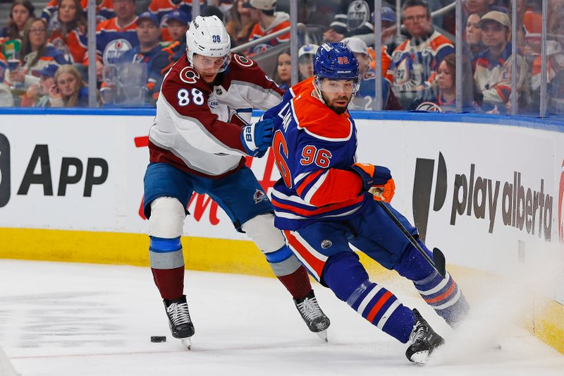 Nov 8, 2025; Edmonton, Alberta, CAN; Edmonton Oilers defensemen Jake Wahlman (96) and Colorado Avalanche forward Martin Necas (88) battle along the boards for a loose puck  during the second period at Rogers Place. Mandatory Credit: Perry Nelson-Imagn Images