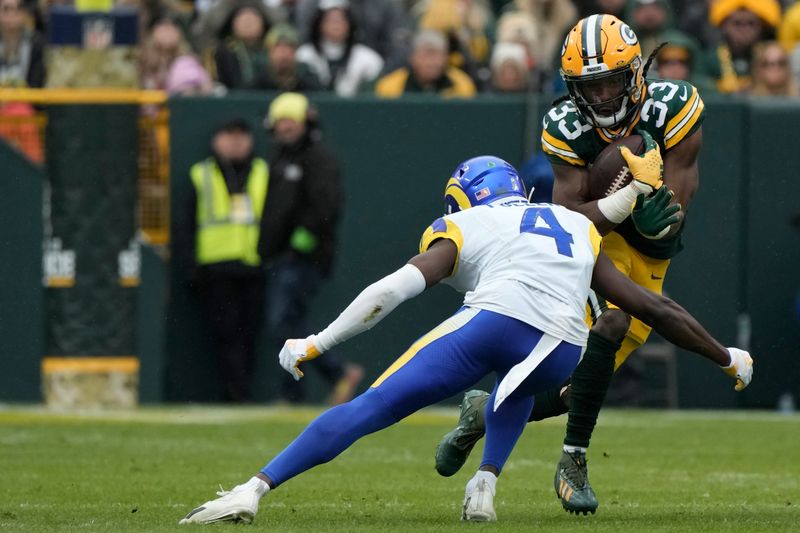 Green Bay Packers running back Aaron Jones (33) runs with the football as Los Angeles Rams safety Jordan Fuller (4) attempts to tackle during the first half of an NFL football game Sunday, Nov. 5, 2023, in Green Bay, Wis. (AP Photo/Morry Gash)