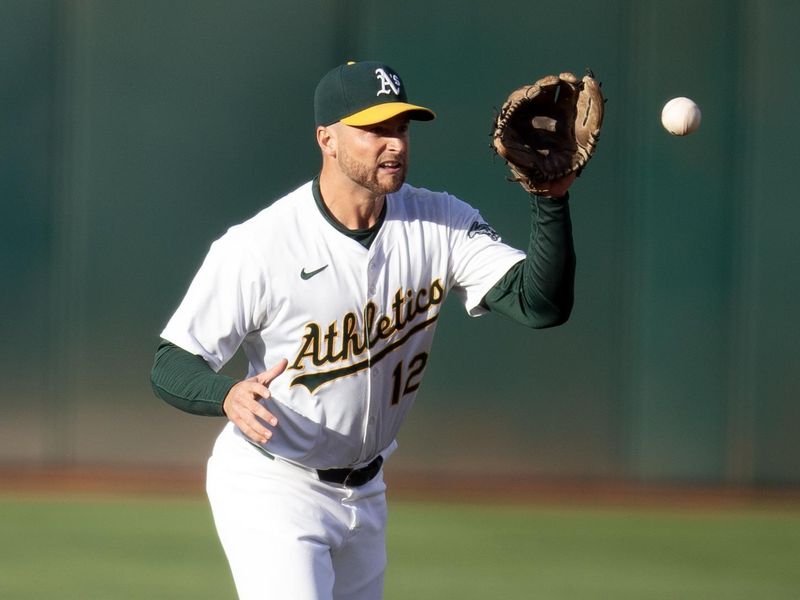 Jun 7, 2024; Oakland, California, USA; Oakland Athletics shortstop Max Schuemann (12) fields a ground ball by Toronto Blue Jays first baseman Vladimir Guerrero Jr. during the first inning at Oakland-Alameda County Coliseum. Mandatory Credit: D. Ross Cameron-USA TODAY Sports