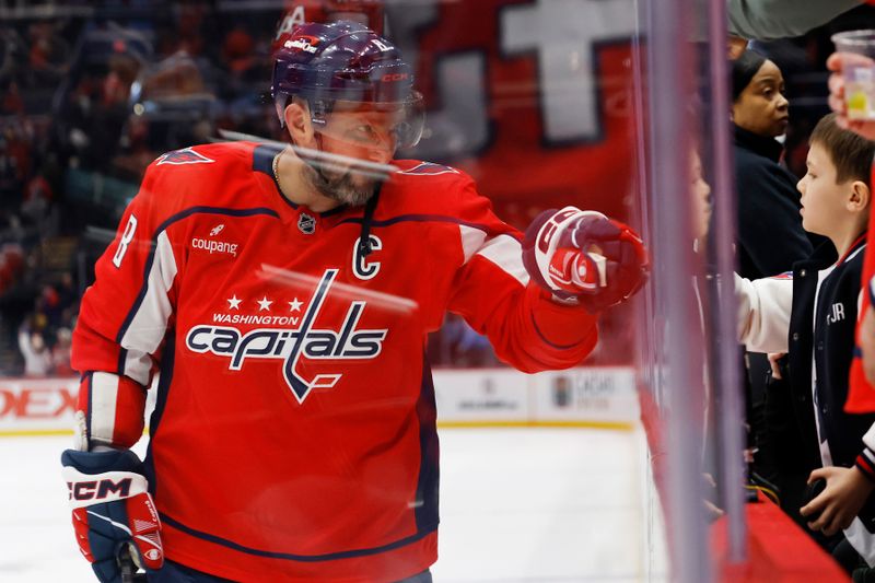 Nov 19, 2025; Washington, District of Columbia, USA; Washington Capitals left wing Alex Ovechkin (8) fist bumps through the glass with his son Sergei (R) after the Capitals' game against the Edmonton Oilers at Capital One Arena. Mandatory Credit: Geoff Burke-Imagn Images