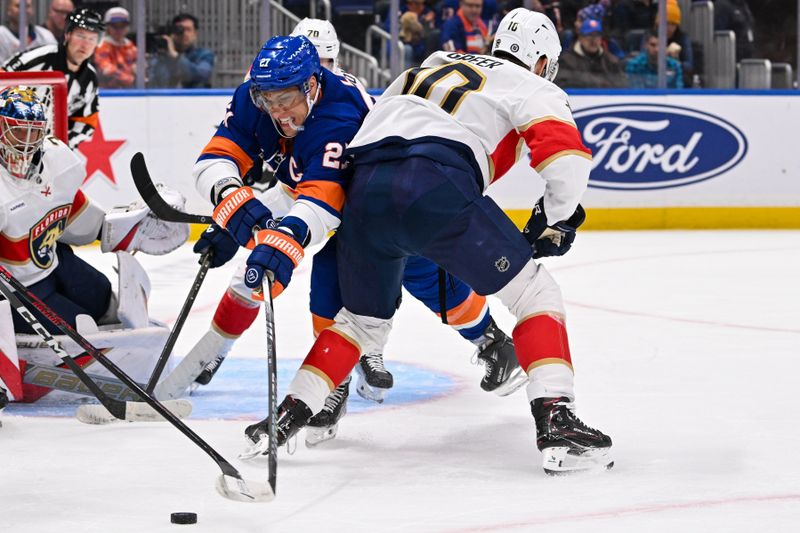 Oct 26, 2024; Elmont, New York, USA;  New York Islanders left wing Anders Lee (27) battle for a loose puck against Florida Panthers left wing A.J. Greer (10) during the second period at UBS Arena. Mandatory Credit: Dennis Schneidler-Imagn Images