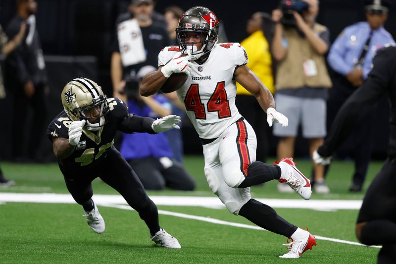 Tampa Bay Buccaneers running back Sean Tucker (44) runs toward the end zone to score past New Orleans Saints safety J.T. Gray (48) during the first half of an NFL football game in New Orleans, Sunday, Oct. 13, 2024. (AP Photo/Butch Dill)