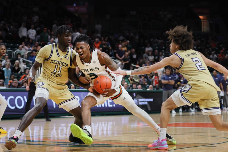 Feb 24, 2024; Coral Gables, Florida, USA; Miami Hurricanes guard Christian Watson (3) drives to the basket against Georgia Tech Yellow Jackets forward Baye Ndongo (11) and guard Naithan George (2) during the second half at Watsco Center. Mandatory Credit: Sam Navarro-USA TODAY Sports