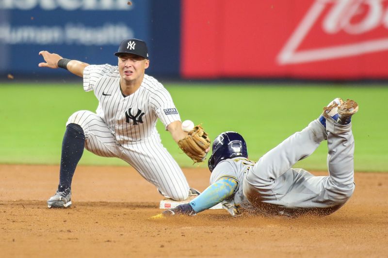 Sep 8, 2023; Bronx, New York, USA;  New York Yankees shortstop Anthony Volpe (11) is unable to hold onto the ball during a stolen base attempt by Milwaukee Brewers catcher William Contreras (24) in the seventh inning  at Yankee Stadium. Mandatory Credit: Wendell Cruz-USA TODAY Sports