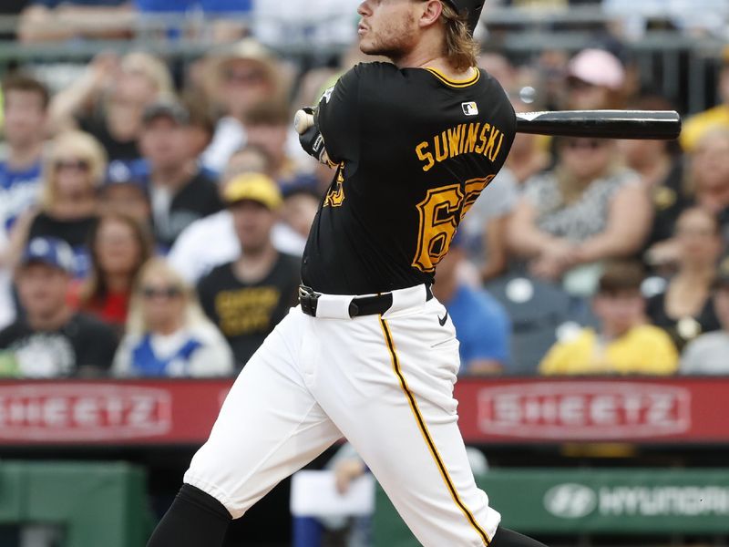 Jun 4, 2024; Pittsburgh, Pennsylvania, USA;  Pittsburgh Pirates center fielder Jack Suwinski (65) hits a solo home run against the Los Angeles Dodgers during the third inning at PNC Park. Mandatory Credit: Charles LeClaire-USA TODAY Sports