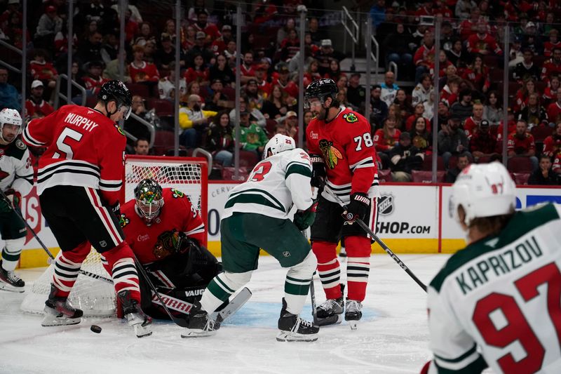 Oct 4, 2024; Chicago, Illinois, USA; Chicago Blackhawks goaltender Petr Mrazek (34) makes a save on Minnesota Wild center Marco Rossi (23) during the second period at United Center. Mandatory Credit: David Banks-Imagn Images