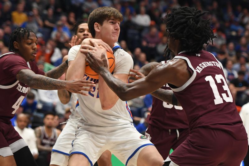 Mar 16, 2024; Nashville, TN, USA; Florida Gators forward Alex Condon (21) grabs a rebound against Texas A&M Aggies forward Solomon Washington (13) during the first half at Bridgestone Arena. Mandatory Credit: Christopher Hanewinckel-USA TODAY Sports