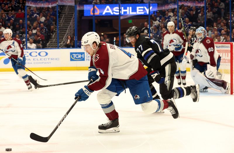 Feb 15, 2024; Tampa, Florida, USA; Colorado Avalanche defenseman Bowen Byram (4) skates with the puck as Tampa Bay Lightning defenseman Victor Hedman (77) defends during the third period at Amalie Arena. Mandatory Credit: Kim Klement Neitzel-USA TODAY Sports