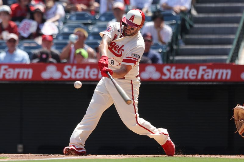 Sep 10, 2023; Anaheim, California, USA; Los Angeles Angels first baseman Mike Moustakas (8) hits a sacrifice fly ball to score Los Angeles Angels right fielder Randal Grichuk (15) during the first inning of a game against the Cleveland Guardians at Angel Stadium. Mandatory Credit: Jessica Alcheh-USA TODAY Sports