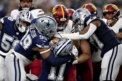 Washington Commanders quarterback Jayden Daniels (5) is sacked by Dallas Cowboys defensive end Chauncey Golston (99) and linebacker Micah Parsons (11) and defensive tackle Osa Odighizuwa (97) during an NFL football game in Arlington, Texas, Sunday, Jan. 5, 2025. (AP Photo/Jerome Miron)