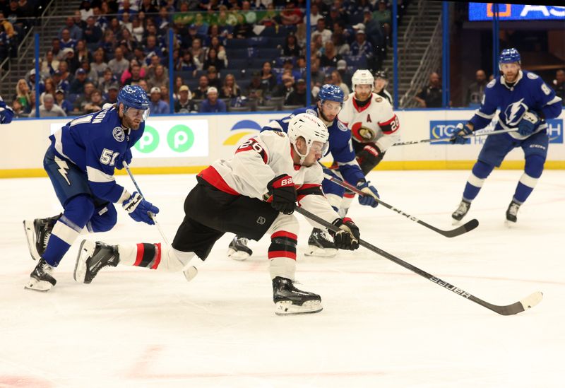 Apr 11, 2024; Tampa, Florida, USA; Ottawa Senators defenseman Erik Brannstrom (26) passes the puck as Tampa Bay Lightning left wing Austin Watson (51) defends during the second period at Amalie Arena. Mandatory Credit: Kim Klement Neitzel-USA TODAY Sports