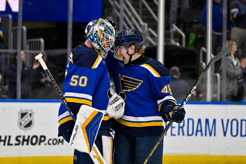 Jan 11, 2024; St. Louis, Missouri, USA;  St. Louis Blues defenseman Scott Perunovich (48) and goaltender Jordan Binnington (50) celebrate after the Blues defeated the New York Rangers at Enterprise Center. Mandatory Credit: Jeff Curry-USA TODAY Sports