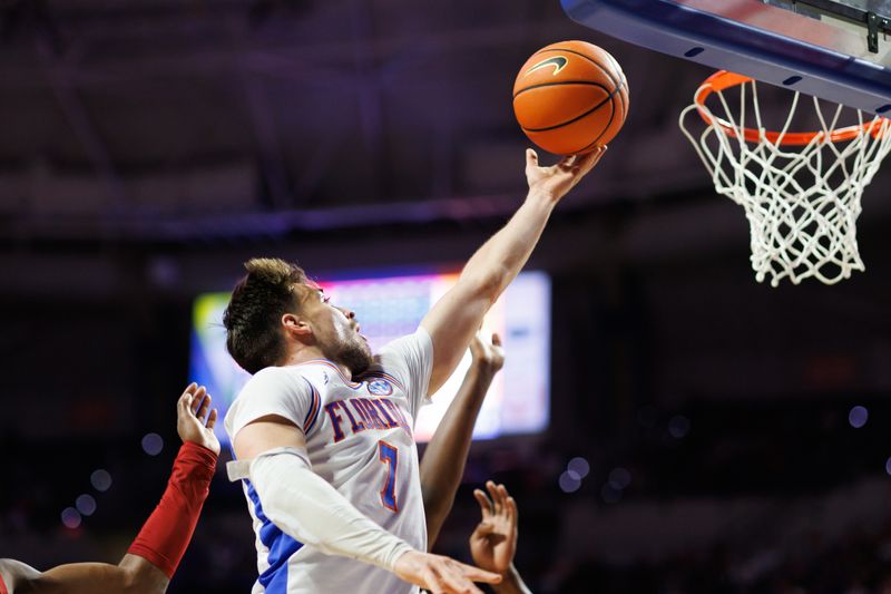Feb 1, 2026; Gainesville, Florida, USA; Florida Gators guard Urban Klavzar (7) makes a layup over Alabama Crimson Tide guard Latrell Wrightsell Jr. (3) during the second half at Exactech Arena at the Stephen C. O'Connell Center. Mandatory Credit: Matt Pendleton-Imagn Images