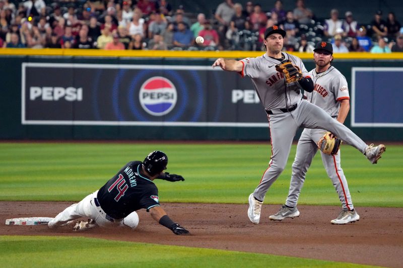 Jun 3, 2024; Phoenix, Arizona, USA; San Francisco Giants shortstop Casey Schmitt (10) turns the double play while avoiding Arizona Diamondbacks catcher Gabriel Moreno (14) in the first inning at Chase Field. Mandatory Credit: Rick Scuteri-USA TODAY Sports