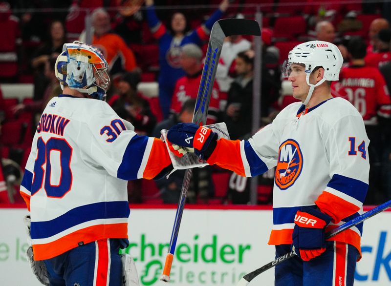 Dec 23, 2023; Raleigh, North Carolina, USA; New York Islanders center Bo Horvat (14) and New York Islanders goaltender Ilya Sorokin (30) celebrate their victory against the Carolina Hurricanes at PNC Arena. Mandatory Credit: James Guillory-USA TODAY Sports