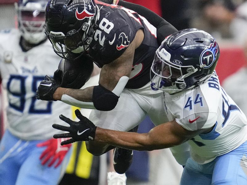 Houston Texans running back Joe Mixon (28) runs the ball past Tennessee Titans safety Mike Brown (44) and cornerback Daryl Worley (35) during the second half an NFL football game Sunday, Nov. 24, 2024, in Houston. (AP Photo/Ashley Landis)