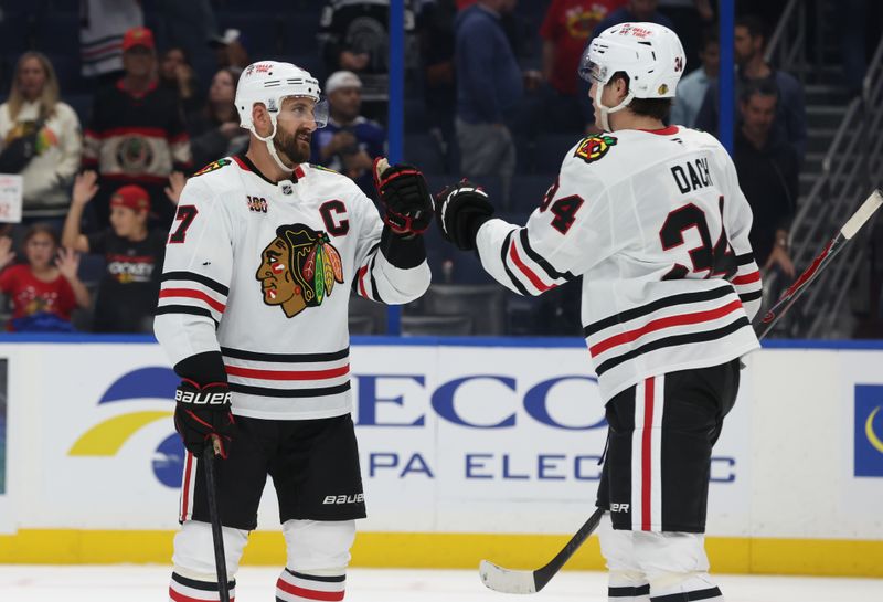 Oct 23, 2025; Tampa, Florida, USA; Chicago Blackhawks left wing Nick Foligno (17) and center Colton Dach (34) celebrate after they beat the Tampa Bay Lightning at Benchmark International Arena. Mandatory Credit: Kim Klement Neitzel-Imagn Images