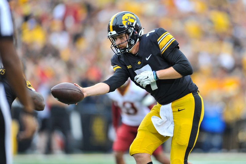 Sep 10, 2022; Iowa City, Iowa, USA; Iowa Hawkeyes quarterback Spencer Petras (7) hands off the ball against the Iowa State Cyclones during the second quarter at Kinnick Stadium. Mandatory Credit: Jeffrey Becker-USA TODAY Sports