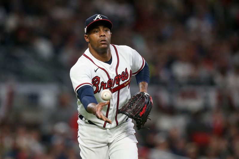 Oct 12, 2022; Atlanta, Georgia, USA; Atlanta Braves relief pitcher Raisel Iglesias (26) fields the ball and throws to first base against the Philadelphia Phillies in the eighth inning during game two of the NLDS for the 2022 MLB Playoffs at Truist Park. Mandatory Credit: Brett Davis-USA TODAY Sports