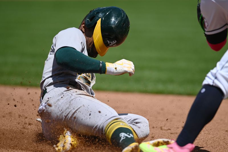 Jun 22, 2023; Cleveland, Ohio, USA; Oakland Athletics left fielder Tony Kemp (5) slides into third advancing on a ground out during the fifth inning against the Cleveland Guardians at Progressive Field. Mandatory Credit: Ken Blaze-USA TODAY Sports