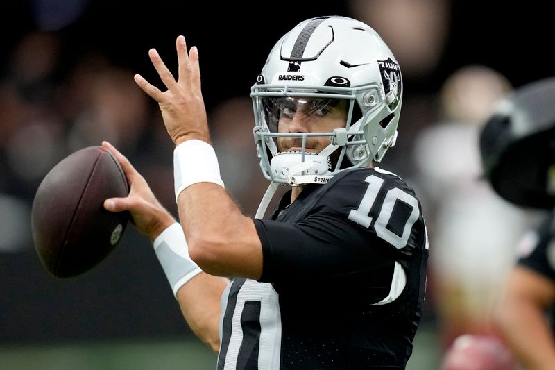 Las Vegas Raiders quarterback Jimmy Garoppolo (10) warms up prior to an NFL preseason football game against the San Francisco 49ers, Sunday, Aug. 13, 2023, in Las Vegas. (AP Photo/John Locher)