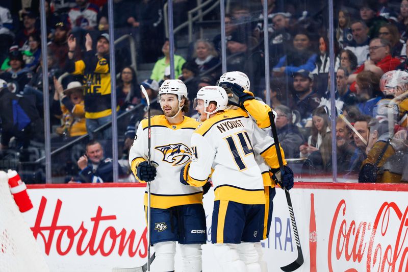 Mar 13, 2024; Winnipeg, Manitoba, CAN; Nashville Predators forward Gustav Nyquist (14) is congratulated by his team mates on his goal against the Winnipeg Jets during the first period at Canada Life Centre. Mandatory Credit: Terrence Lee-USA TODAY Sports