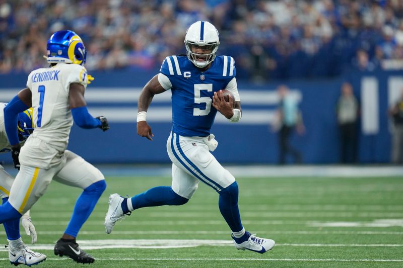 Indianapolis Colts quarterback Anthony Richardson (5) scrambles as Los Angeles Rams cornerback Derion Kendrick (1) defends during the first half of an NFL football game, Sunday, Oct. 1, 2023, in Indianapolis. (AP Photo/Michael Conroy)