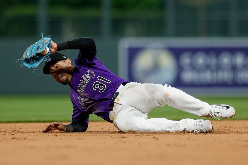 Apr 28, 2025; Denver, Colorado, USA; Colorado Rockies shortstop Alan Trejo (31) fields the ball in the eighth inning against the Atlanta Braves at Coors Field. Mandatory Credit: Isaiah J. Downing-Imagn Images
