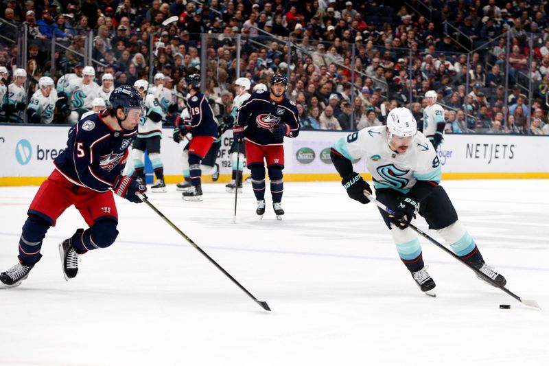 Mar 21, 2026; Columbus, Ohio, USA; Seattle Kraken center Chandler Stephenson (9) carries the puck as Columbus Blue Jackets defenseman Denton Mateychuk (5) defends during the first period at Nationwide Arena. Mandatory Credit: Russell LaBounty-Imagn Images