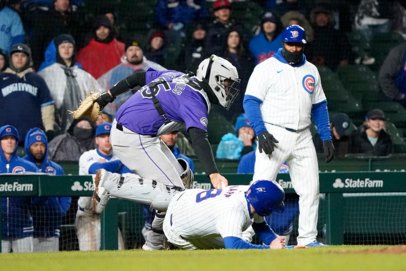 Apr 3, 2024; Chicago, Illinois, USA; Colorado Rockies catcher Jacob Stallings (25) tags out Chicago Cubs left fielder Ian Happ (8) during the eighth inning at Wrigley Field. Mandatory Credit: David Banks-USA TODAY Sports