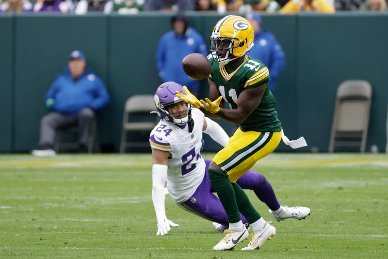 Green Bay Packers wide receiver Jayden Reed (11) catches a pass while defended by Minnesota Vikings safety Camryn Bynum (24) during the second half of an NFL football game Sunday, Oct. 29, 2023, in Green Bay, Wis. (AP Photo/Mike Roemer)