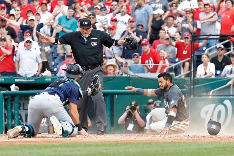 May 25, 2024; Washington, District of Columbia, USA; Washington Nationals catcher Keibert Ruiz (20) scores a run ahead of a tag by Seattle Mariners catcher Cal Raleigh (29) during the seventh inning at Nationals Park. Mandatory Credit: Geoff Burke-USA TODAY Sports