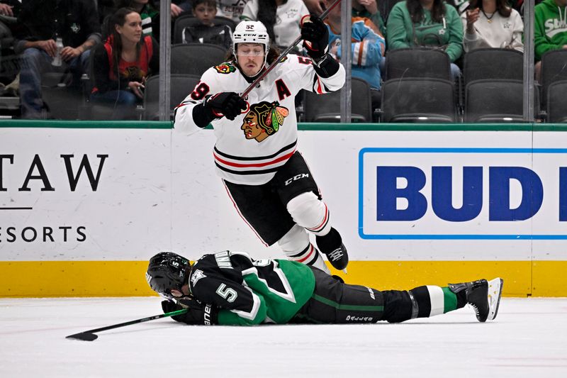 Mar 8, 2026; Dallas, Texas, USA; Chicago Blackhawks left wing Tyler Bertuzzi (59) leaps over Dallas Stars defenseman Nils Lundkvist (5) during the first period at the American Airlines Center. Mandatory Credit: Jerome Miron-Imagn Images