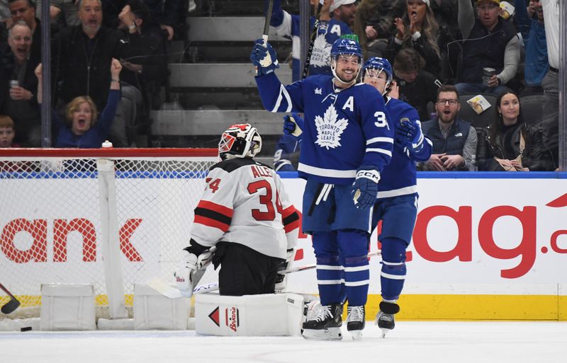 Apr 11, 2024; Toronto, Ontario, CAN; Toronto Maple Leafs forward Auston Matthews (34) celebrates with forward Tyler Bertuzzi (59) after scoring a goal past New Jersey Devils goalie Jake Allen (34) in the second period at Scotiabank Arena. Mandatory Credit: Dan Hamilton-USA TODAY Sports