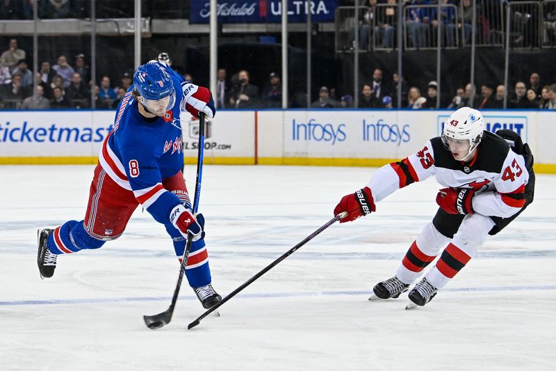 Dec 2, 2024; New York, New York, USA;  New York Rangers defenseman Jacob Trouba (8) shoots the puck as New Jersey Devils defenseman Luke Hughes (43) defends during the second period at Madison Square Garden. Mandatory Credit: Dennis Schneidler-Imagn Images