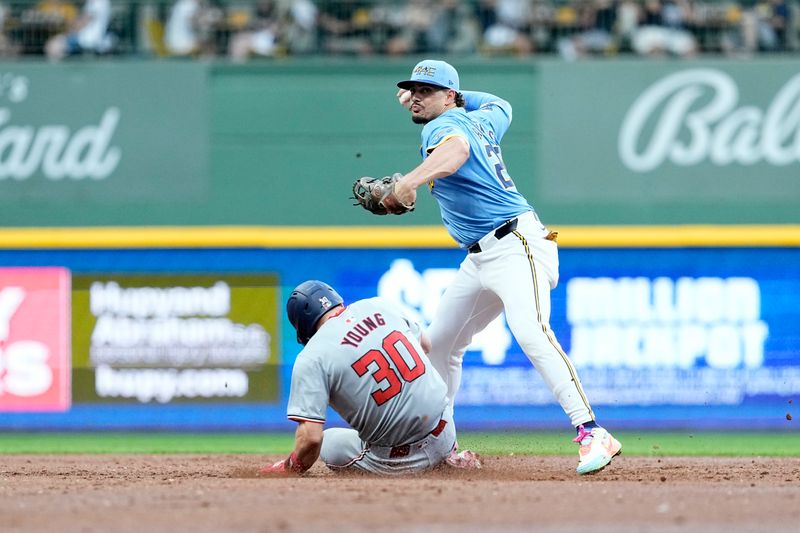 Jul 12, 2024; Milwaukee, Wisconsin, USA;  Milwaukee Brewers shortstop Willy Adames (27) turns a double play as Washington Nationals center fielder Jacob Young (30) slides into second base during the third inning at American Family Field. Mandatory Credit: Jeff Hanisch-USA TODAY Sports