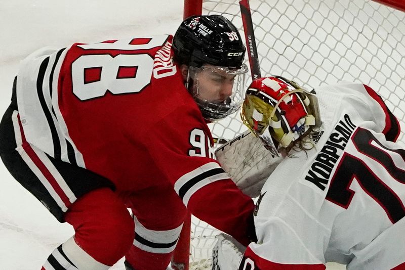 Feb 17, 2024; Chicago, Illinois, USA; Chicago Blackhawks center Connor Bedard (98) and Ottawa Senators goaltender Joonas Korpisalo (70) get close in the goal during the second period at United Center. Mandatory Credit: David Banks-USA TODAY Sports