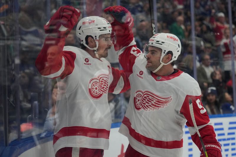 Nov 8, 2024; Toronto, Ontario, CAN; Detroit Red Wings forward Alex DeBrincat (93) congratulates forward Dylan Larkin (71) on his goal against the Toronto Maple Leafs during the second period at Scotiabank Arena. Mandatory Credit: John E. Sokolowski-Imagn Images