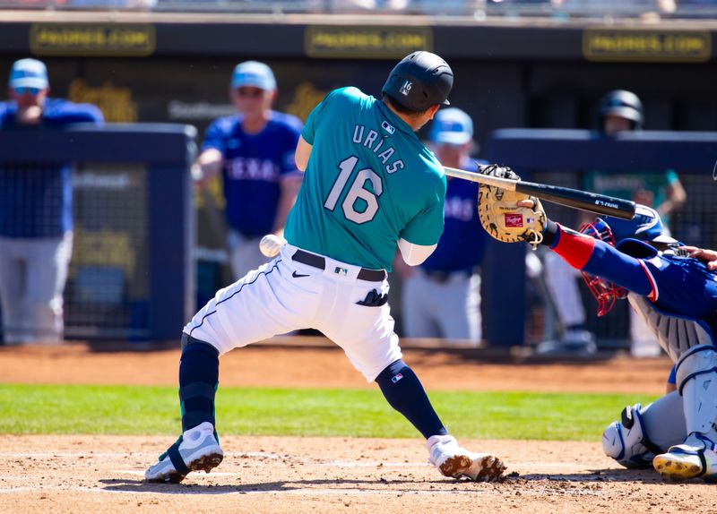 Mar 5, 2024; Peoria, Arizona, USA; Seattle Mariners infielder Luis Urias is hit by a pitch against the Texas Rangers during a spring training baseball game at Peoria Sports Complex. Mandatory Credit: Mark J. Rebilas-USA TODAY Sports