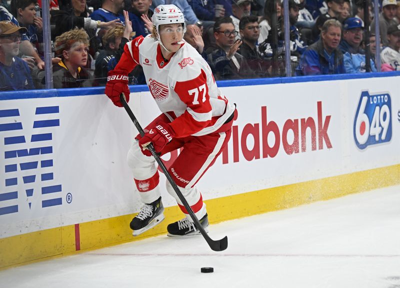 Oct 13, 2025; Toronto, Ontario, CAN; Detroit Red Wings defenceman Simon Edvinsson (77) controls the puck in the first period against the Toronto Maple Leafs at Scotiabank Arena. Mandatory Credit: Gerry Angus-Imagn Images
