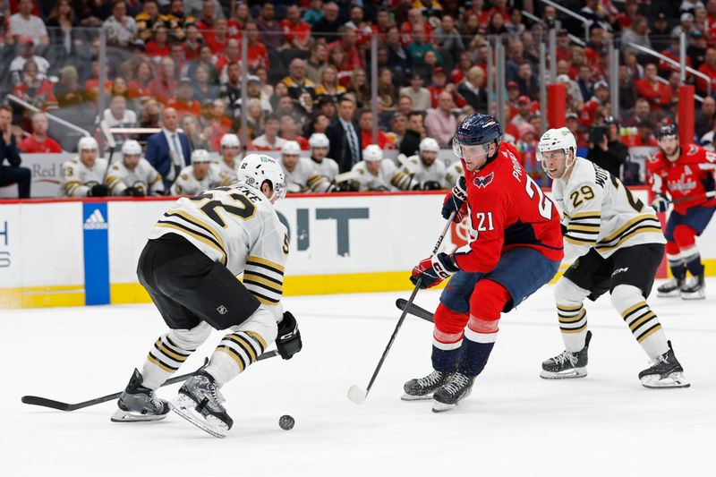 Apr 15, 2024; Washington, District of Columbia, USA; Washington Capitals center Aliaksei Protas (21) shoots the puck as Boston Bruins defenseman Andrew Peeke (52) defends in the third period at Capital One Arena. Mandatory Credit: Geoff Burke-USA TODAY Sports