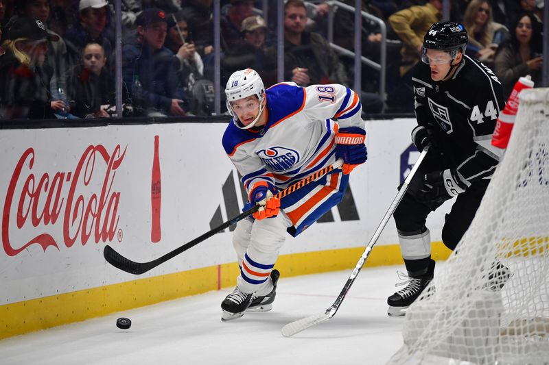 Dec 30, 2023; Los Angeles, California, USA; Edmonton Oilers left wing Zach Hyman (18) moves the puck ahead of Los Angeles Kings defenseman Mikey Anderson (44) during the first period at Crypto.com Arena. Mandatory Credit: Gary A. Vasquez-USA TODAY Sports