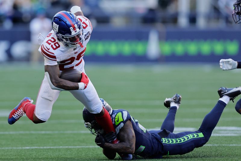 New York Giants running back Tyrone Tracy Jr. (29) is tackled by Seattle Seahawks cornerback Tre Brown (22) during the second half of an NFL football game, Sunday, Oct. 6, 2024, in Seattle. (AP Photo/John Froschauer)