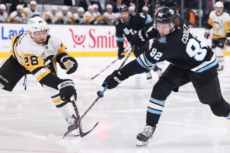 Jan 29, 2025; Salt Lake City, Utah, USA; Pittsburgh Penguins defenseman Marcus Pettersson (28) deflects a shot by Utah Hockey Club center Logan Cooley (92) during the second period at Delta Center. Mandatory Credit: Rob Gray-Imagn Images