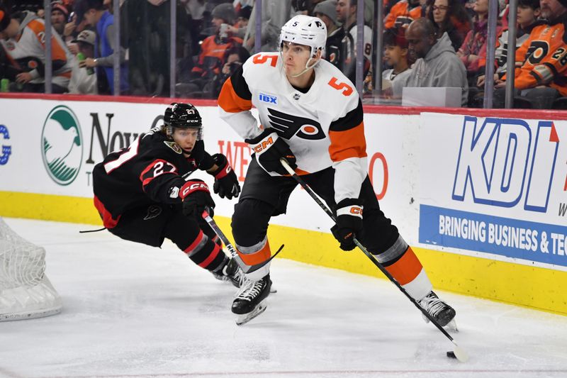 Mar 2, 2024; Philadelphia, Pennsylvania, USA; Philadelphia Flyers defenseman Egor Zamula (5) clears the puck away from Ottawa Senators left wing Parker Kelly (27) during the second period at Wells Fargo Center. Mandatory Credit: Eric Hartline-USA TODAY Sports