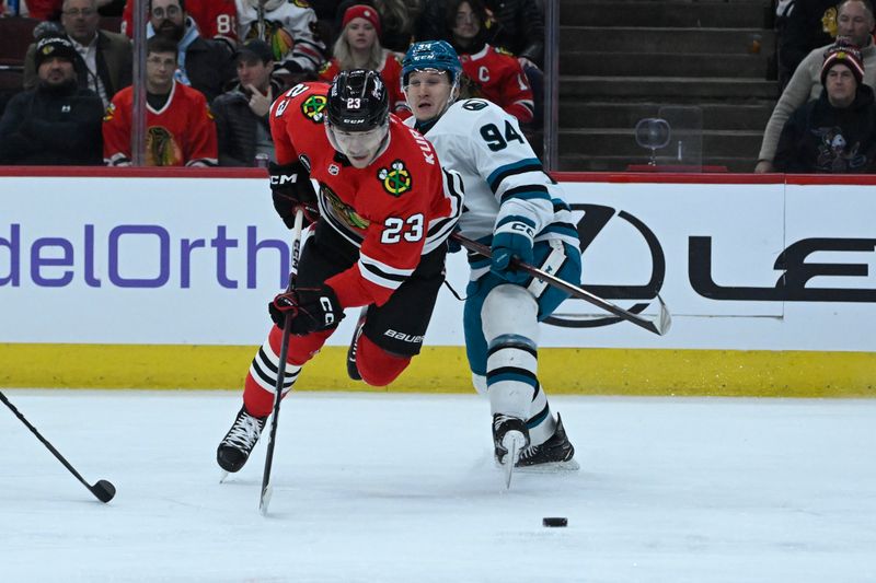 Jan 16, 2024; Chicago, Illinois, USA; Chicago Blackhawks center Philipp Kurashev (23) gets tripped by San Jose Sharks left wing Alexander Barabanov (94) during the first period at United Center. Mandatory Credit: Matt Marton-USA TODAY Sports