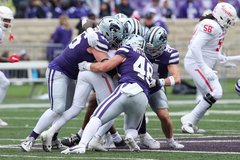 Oct 28, 2023; Manhattan, Kansas, USA; Houston Cougars running back Stacy Sneed (21) is tackled by Kansas State Wildcats defenders during the fourth quarter at Bill Snyder Family Football Stadium. Mandatory Credit: Scott Sewell-USA TODAY Sports