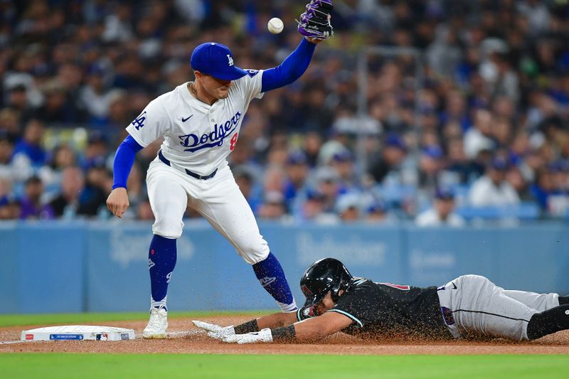 May 22, 2024; Los Angeles, California, USA; Arizona Diamondbacks catcher Gabriel Moreno (14) reaches third against Los Angeles Dodgers third baseman Enrique Hernandez (8) during the fifth inning at Dodger Stadium. Mandatory Credit: Gary A. Vasquez-USA TODAY Sports